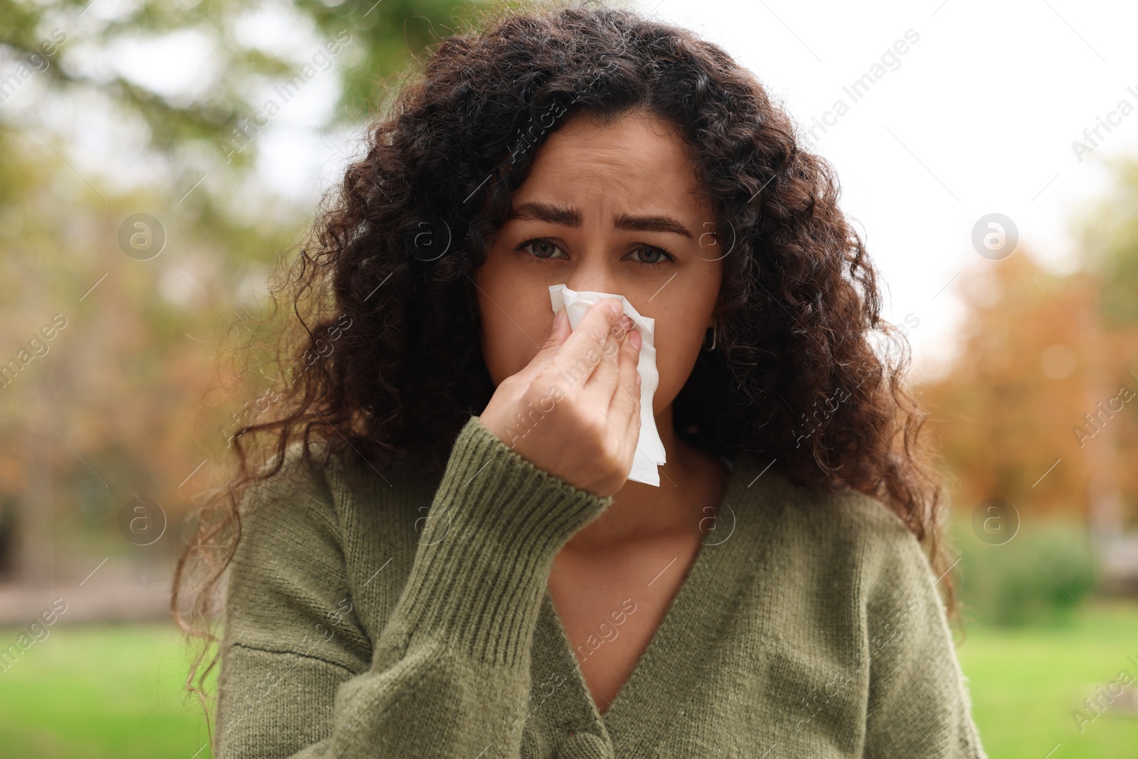 Photo of Young woman with runny nose in park