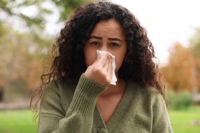 Photo of Young woman with runny nose in park