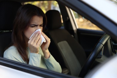 Photo of Young woman with runny nose in car