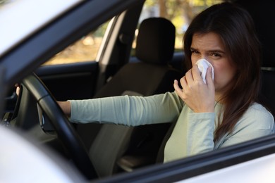 Photo of Young woman with runny nose in car