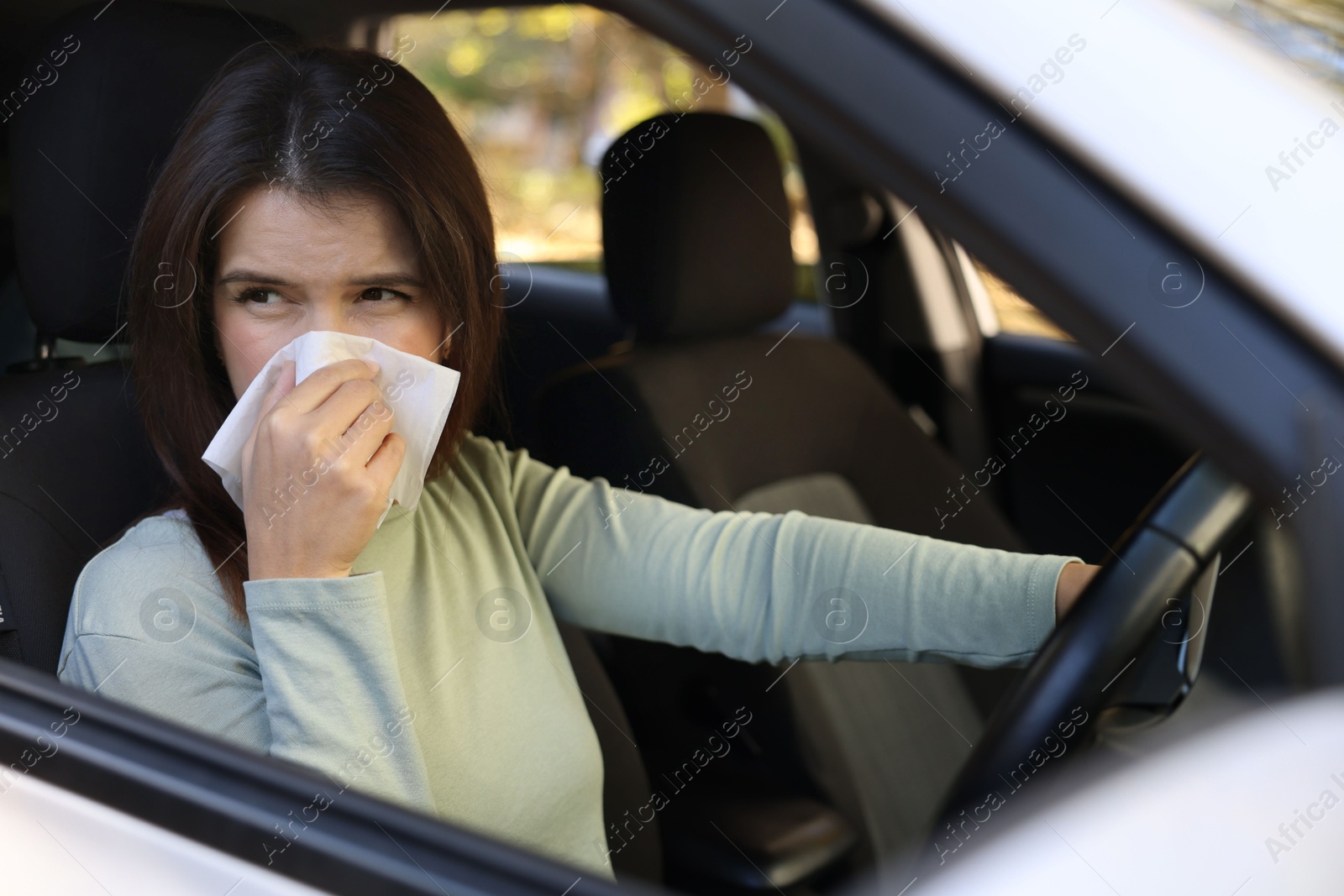 Photo of Young woman with runny nose in car