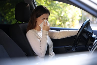 Young woman with runny nose in car