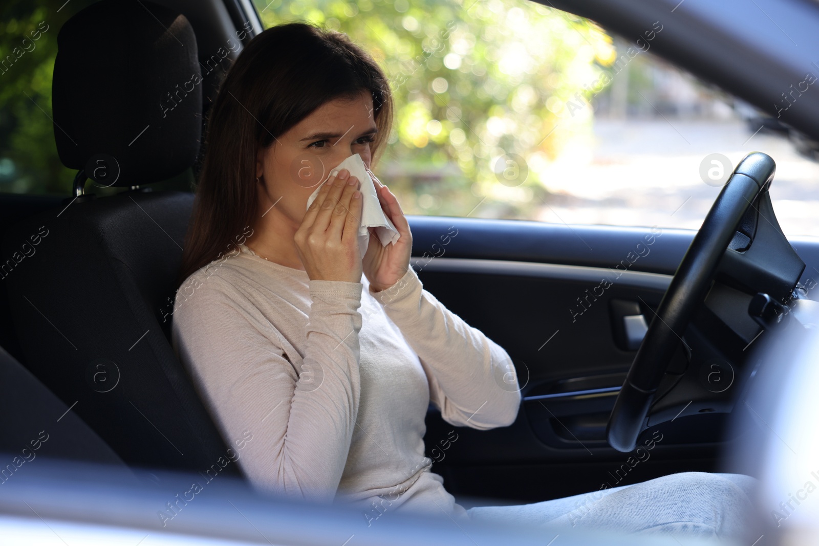 Photo of Young woman with runny nose in car