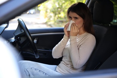 Photo of Young woman with runny nose in car