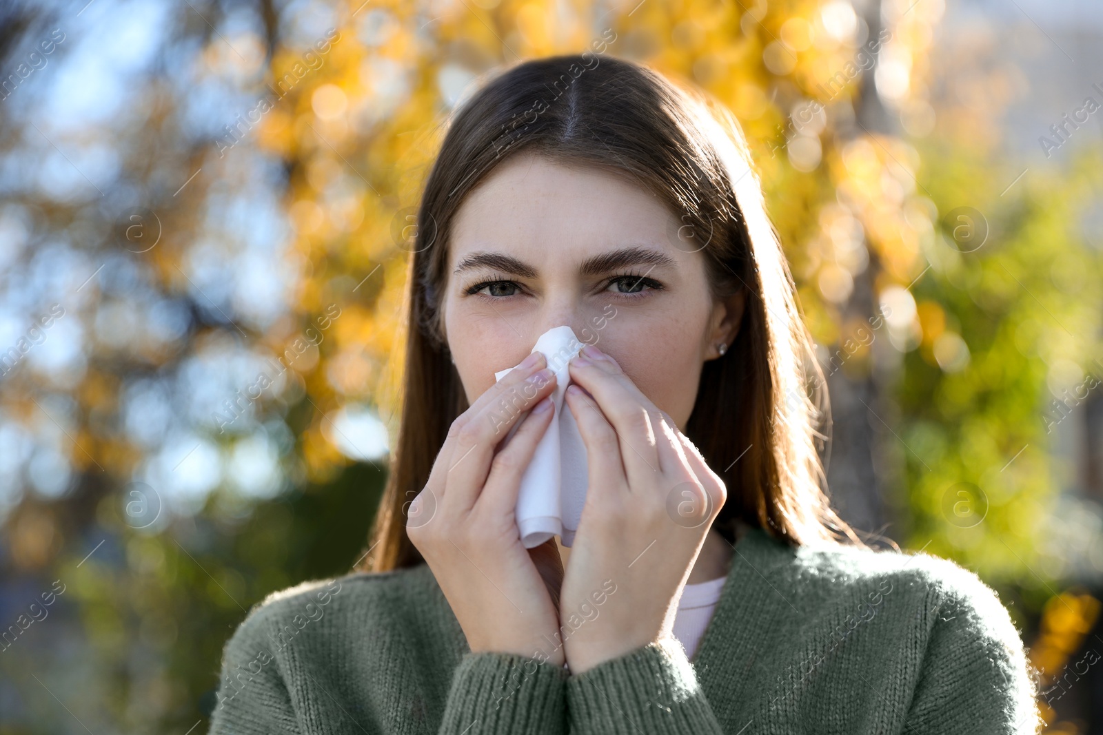 Photo of Young woman with runny nose in park