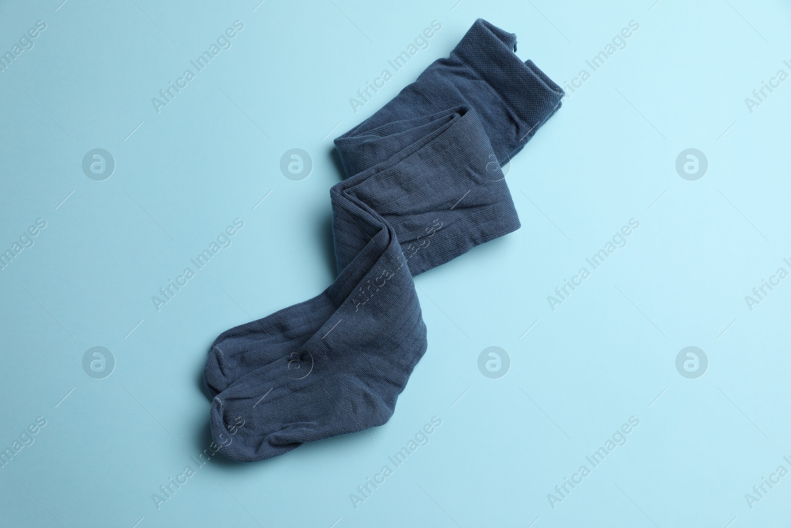 Photo of Beautiful child's tights on light blue background