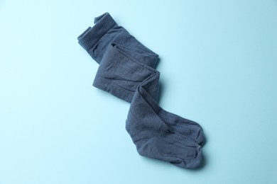 Photo of Beautiful child's tights on light blue background