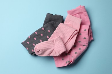 Photo of Different child's tights on light blue background, flat lay