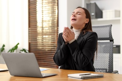 Photo of Sick woman with runny nose at table in office