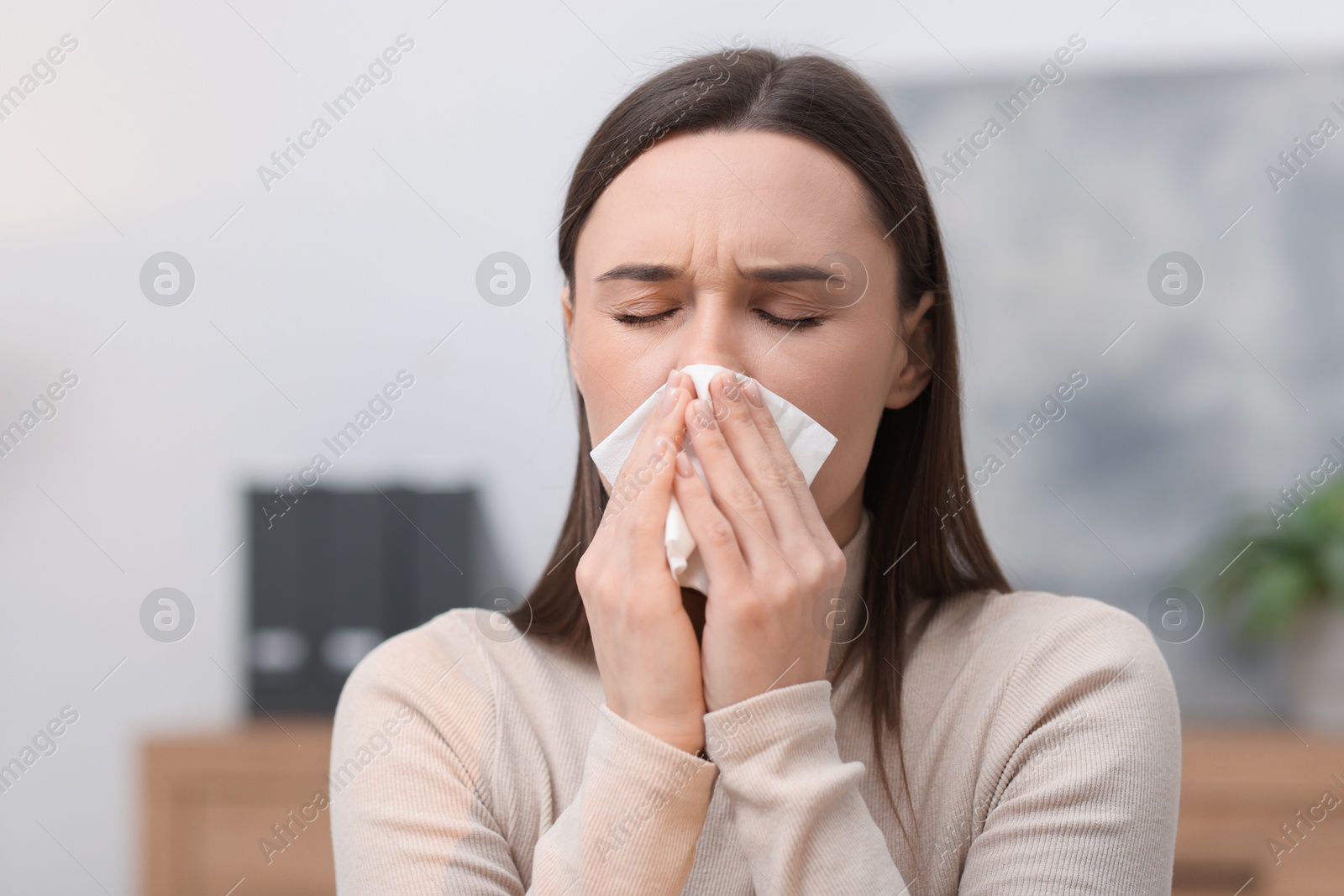 Photo of Sick woman with runny nose in office