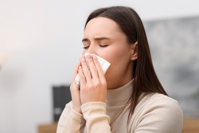 Photo of Sick woman with runny nose in office, space for text