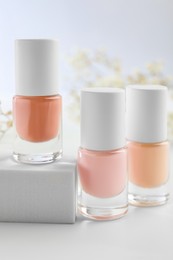 Nail polishes in bottles on white table, closeup