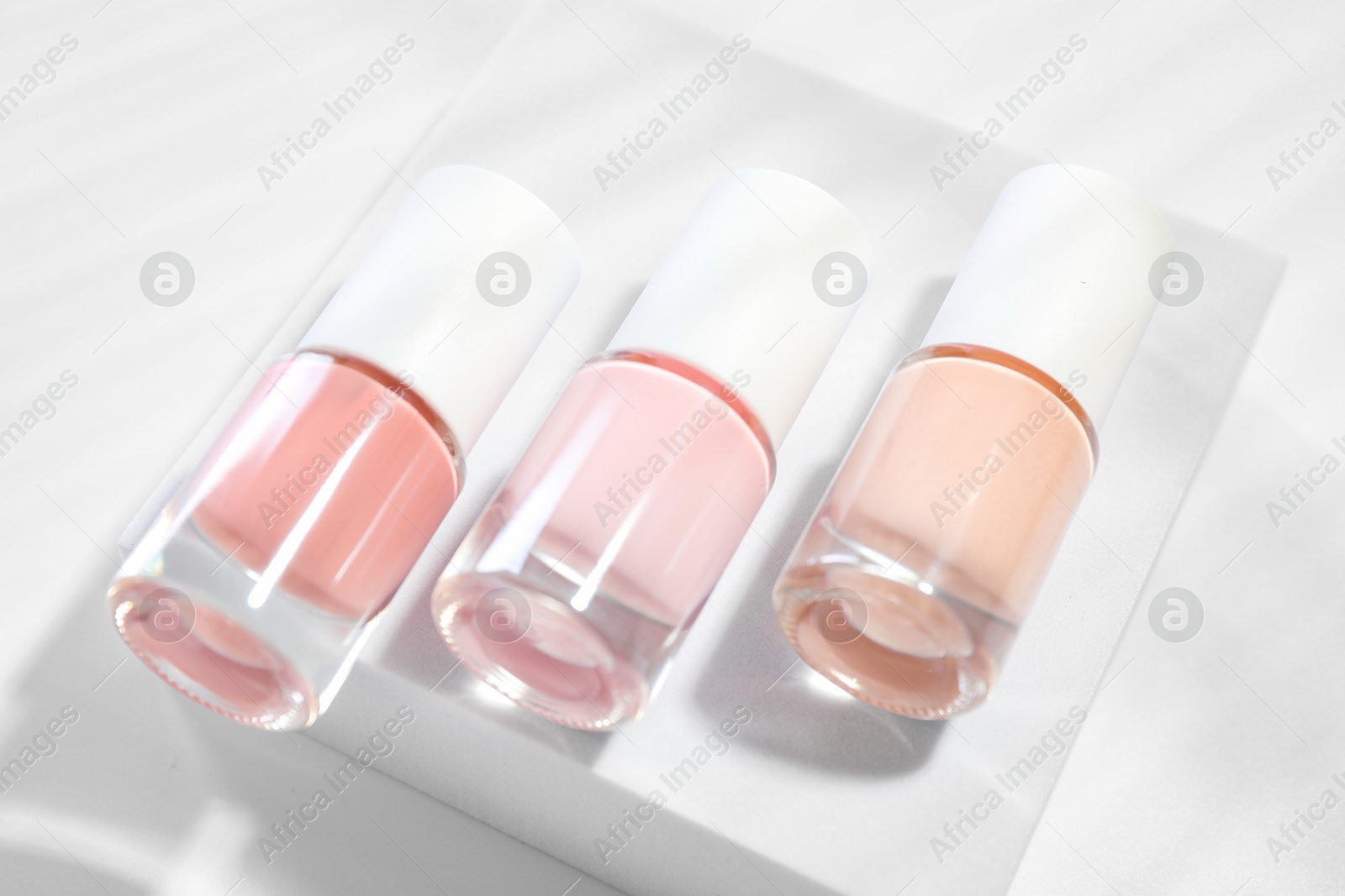 Photo of Nail polishes in bottles on white background