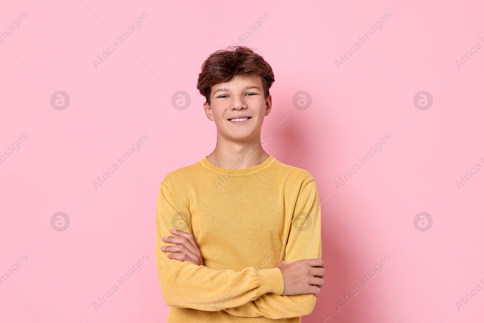 Photo of Portrait of happy teenage boy on pink background