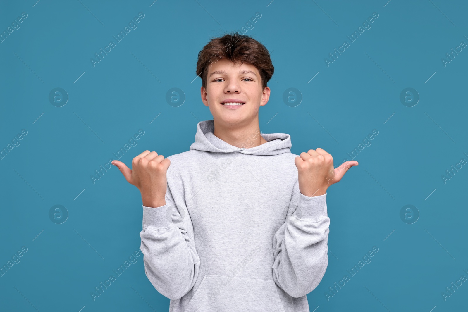 Photo of Happy teenage boy on light blue background