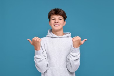 Photo of Happy teenage boy on light blue background