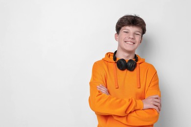 Photo of Teenage boy with headphones on white background, space for text