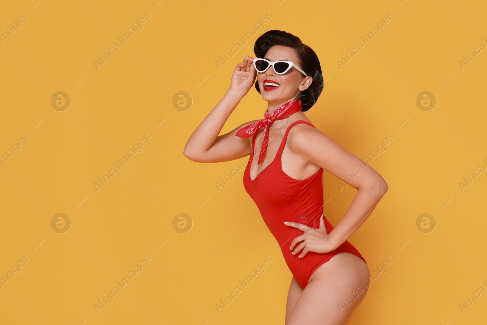 Photo of Pin-up woman in swimsuit on orange background, space for text