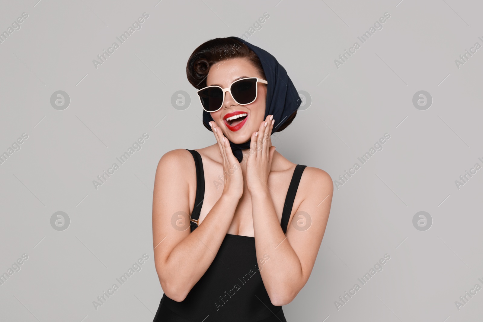 Photo of Pin-up woman in sunglasses on grey background