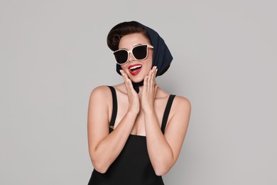 Photo of Pin-up woman in sunglasses on grey background