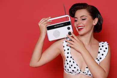 Photo of Pin-up woman in bikini with radio receiver on red background