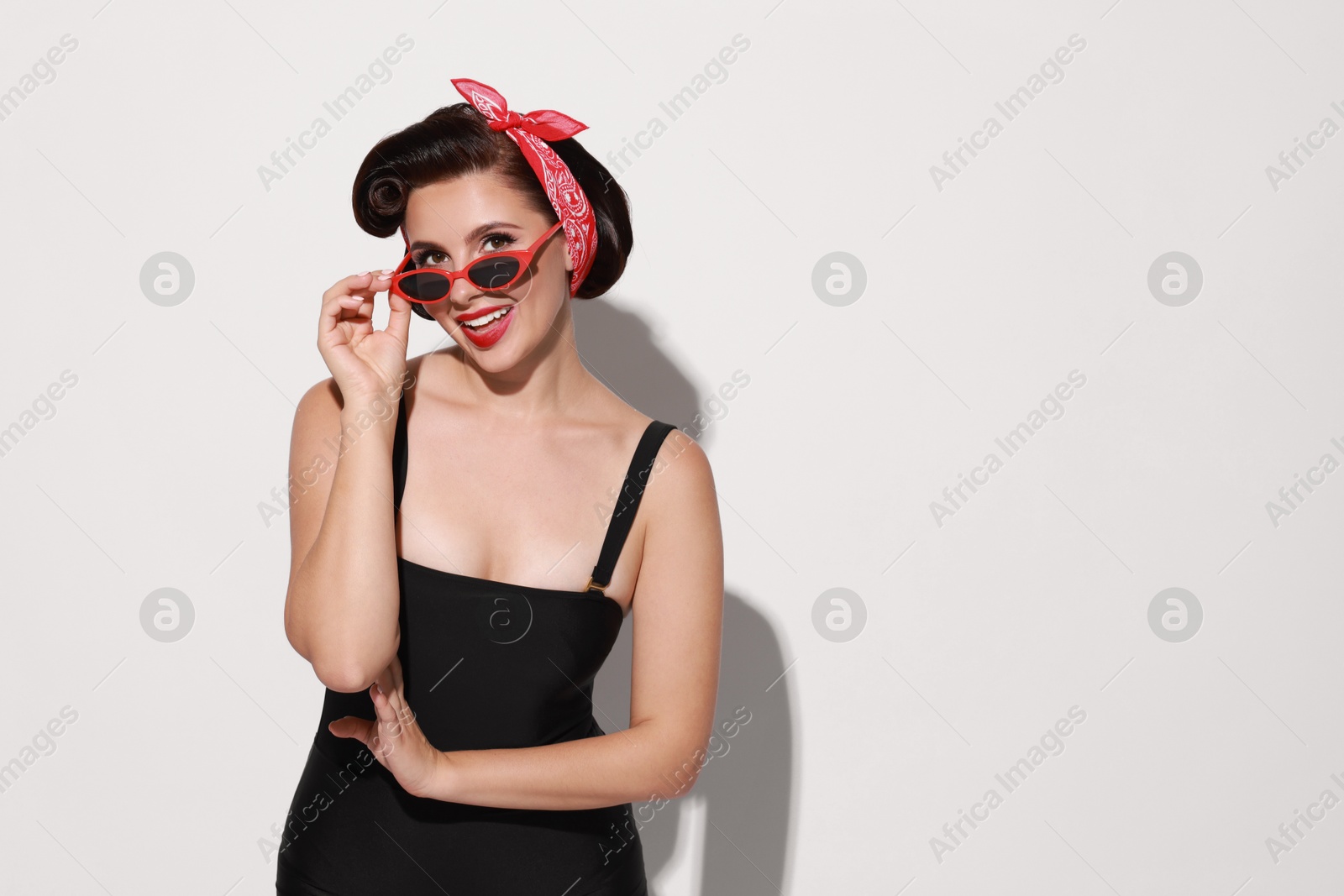 Photo of Portrait of pin-up woman on light background, space for text