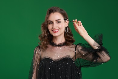 Photo of Smiling woman with makeup brush on green background