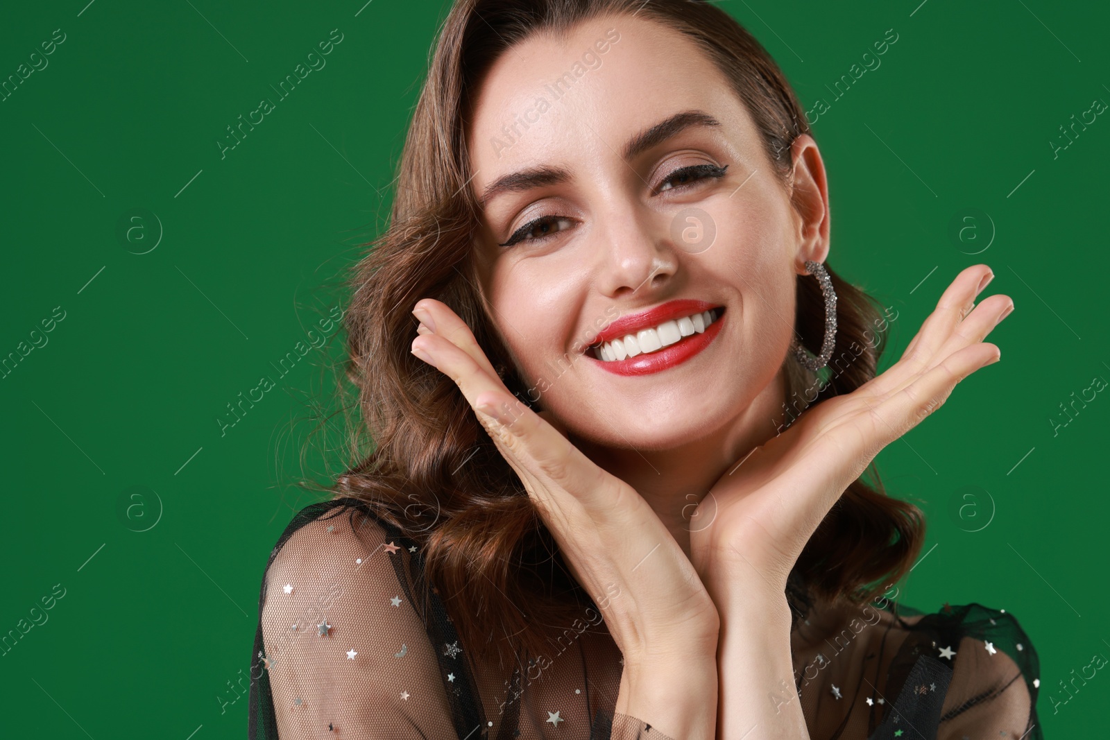 Photo of Portrait of smiling woman with perfect makeup on green background