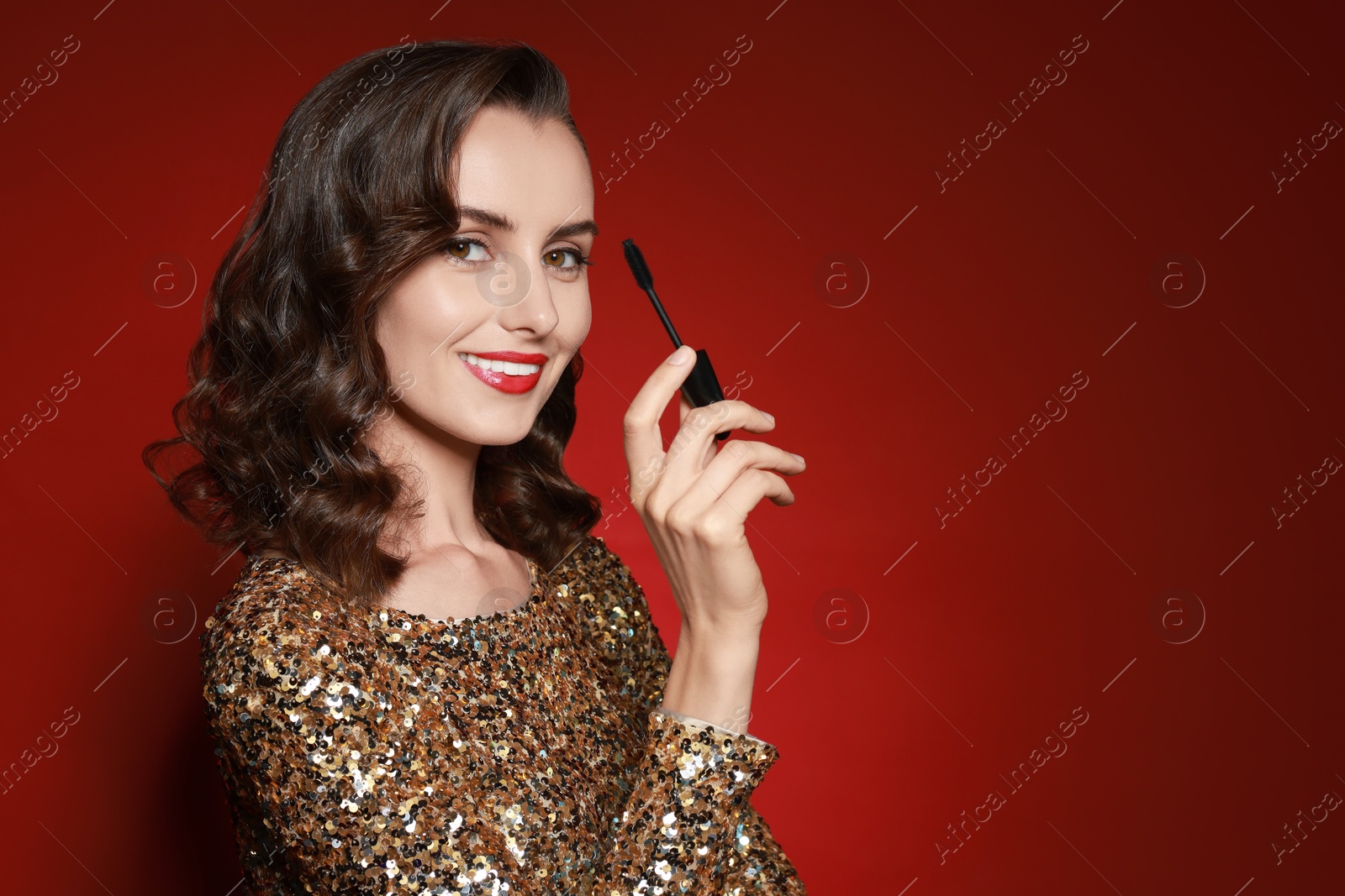 Photo of Smiling woman with makeup brush on red background. Space for text