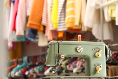 Photo of Vintage sewing machine with thread in workshop