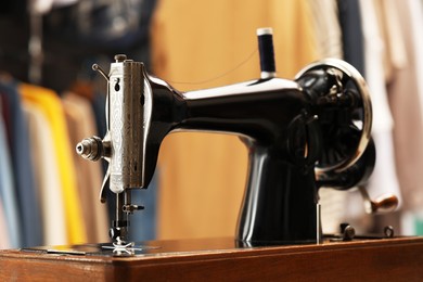 Photo of Vintage sewing machine with thread in workshop, closeup