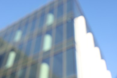 Blurred view of modern building with many windows against light blue sky