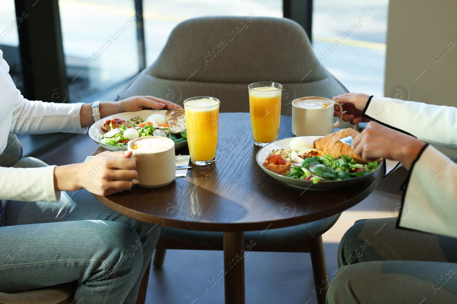 Photo of Women having tasty breakfast in cafe, closeup