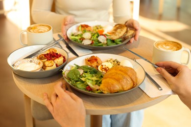 Photo of Women having tasty breakfast in cafe, closeup