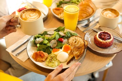 Photo of Woman having tasty breakfast in cafe, closeup