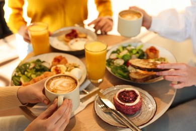 Photo of Women having tasty breakfast in cafe, closeup