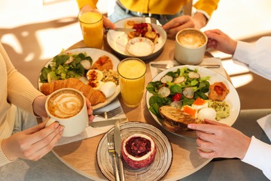 Photo of Women having tasty breakfast in cafe, closeup