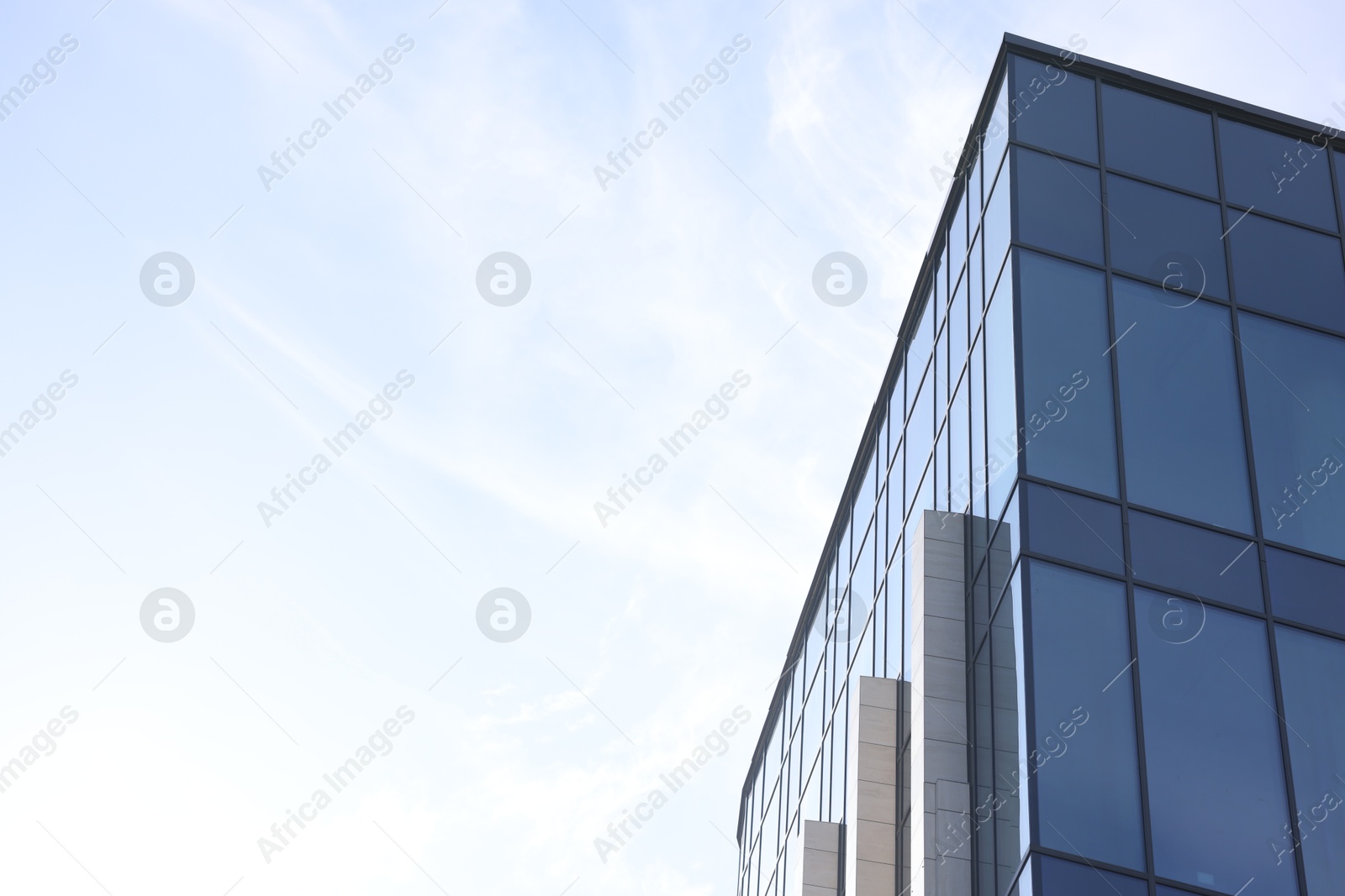 Photo of Exterior of modern building with many windows outdoors, low angle view. Space for text