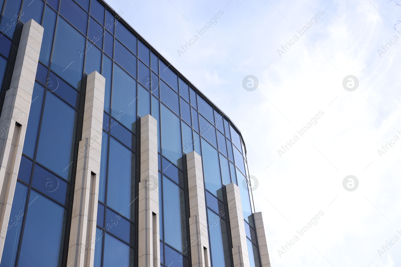 Photo of Exterior of modern building with many windows outdoors, low angle view. Space for text