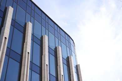 Photo of Exterior of modern building with many windows outdoors, low angle view. Space for text