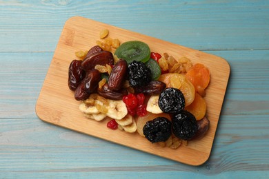 Photo of Mix of different dried fruits on blue wooden table, top view