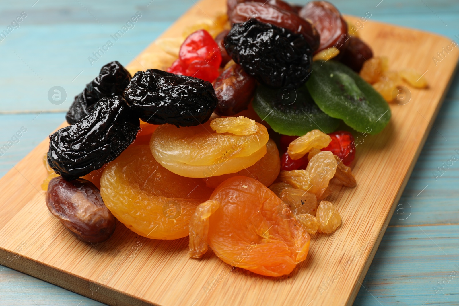 Photo of Mix of different dried fruits on blue wooden table, closeup