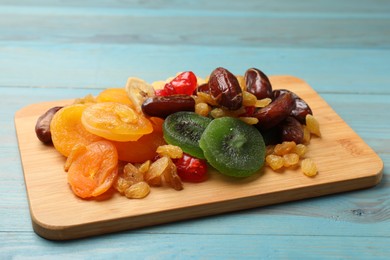 Photo of Mix of different dried fruits on blue wooden table, closeup