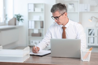 Middle aged man working at table in office