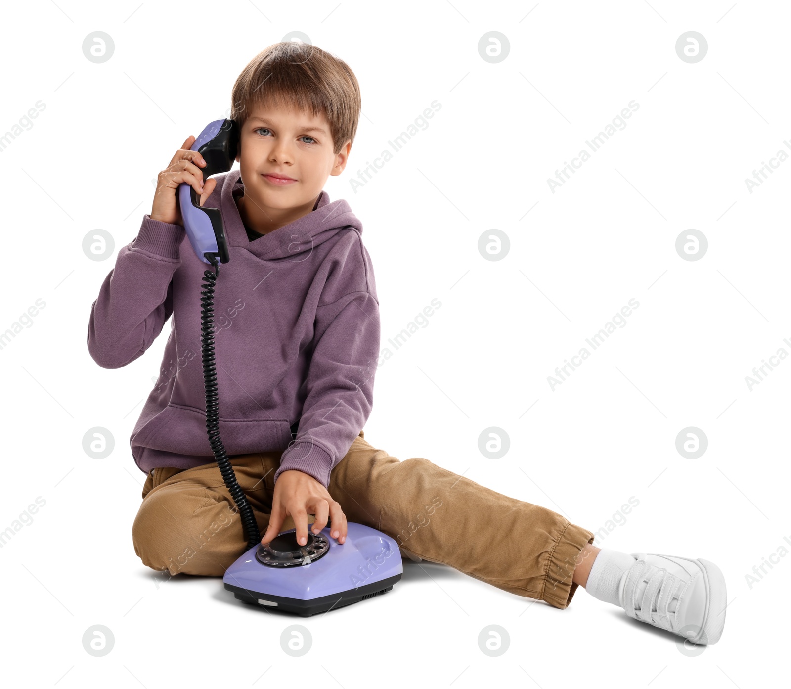 Photo of Cute little boy with old telephone on white background