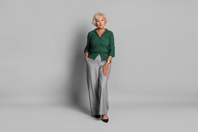 Photo of Full length portrait of beautiful senior woman on light grey background