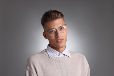 Photo of Handsome young man with stylish haircut on grey background