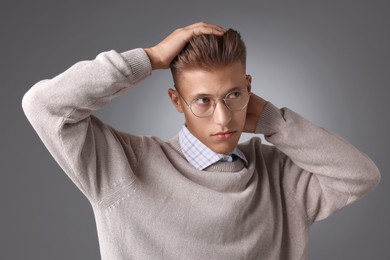 Photo of Handsome young man with stylish haircut on grey background