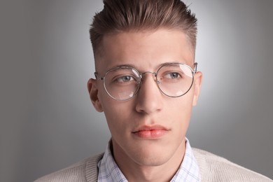 Photo of Handsome young man with stylish haircut on grey background