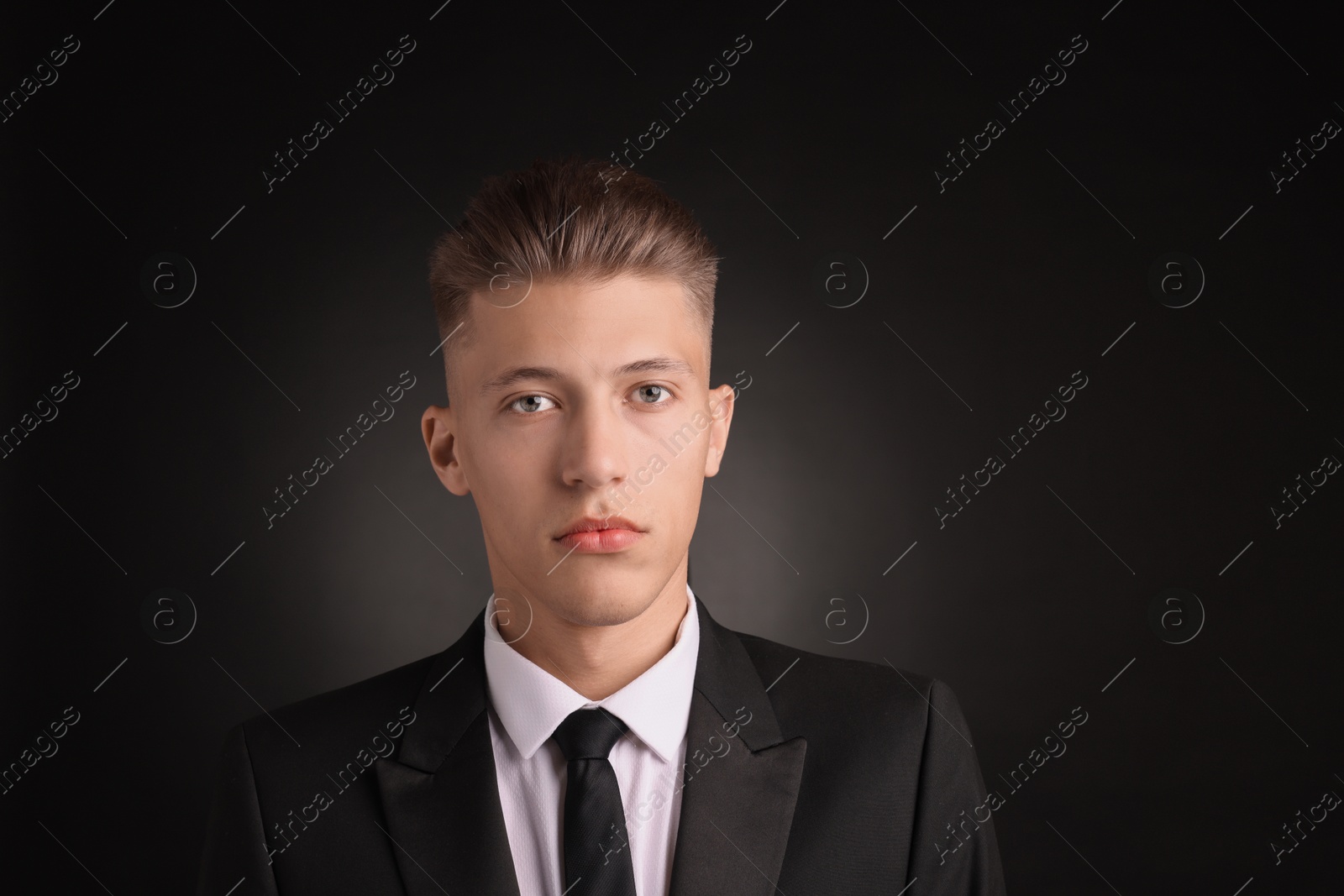 Photo of Confident young man with stylish haircut on black background